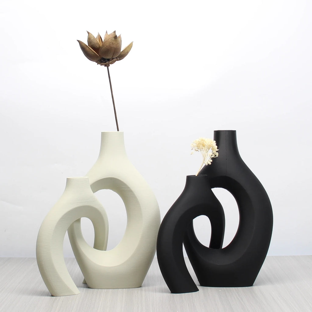 Set of two bohemian-style art vases in matte black and cream with a modern, cut-out circular design.