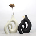 Set of two bohemian-style art vases in matte black and cream with a modern, cut-out circular design.
