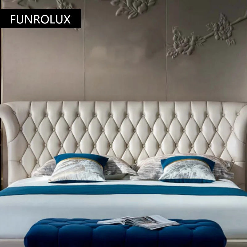 Luxury cream genuine leather double bed with a button-tufted, winged headboard and blue velvet footstool.