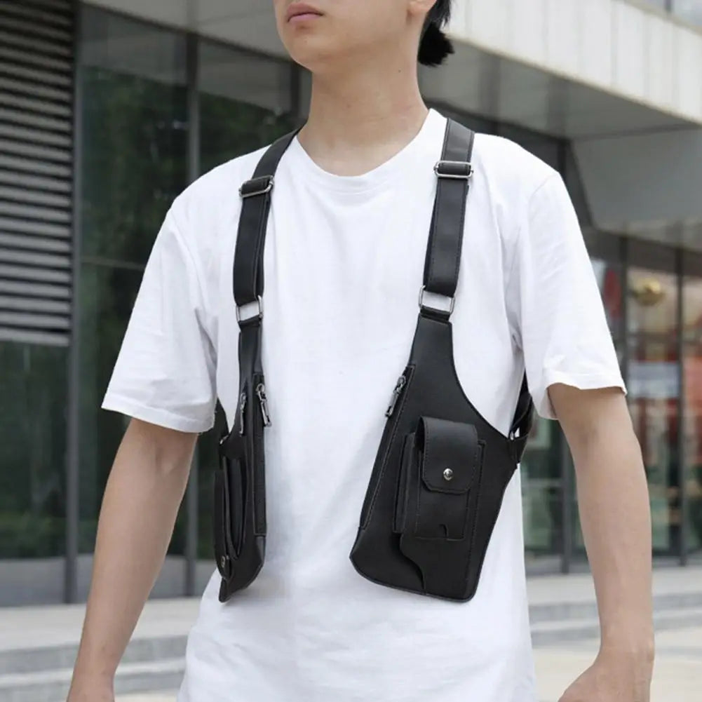 A man wearing a black, dual-pouch tactical crossbody bag harness over a white t-shirt.
