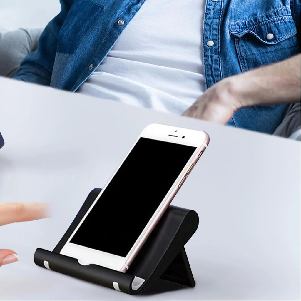 A sleek black smartphone stand holding a white phone on a desk, perfect for hands-free viewing.
