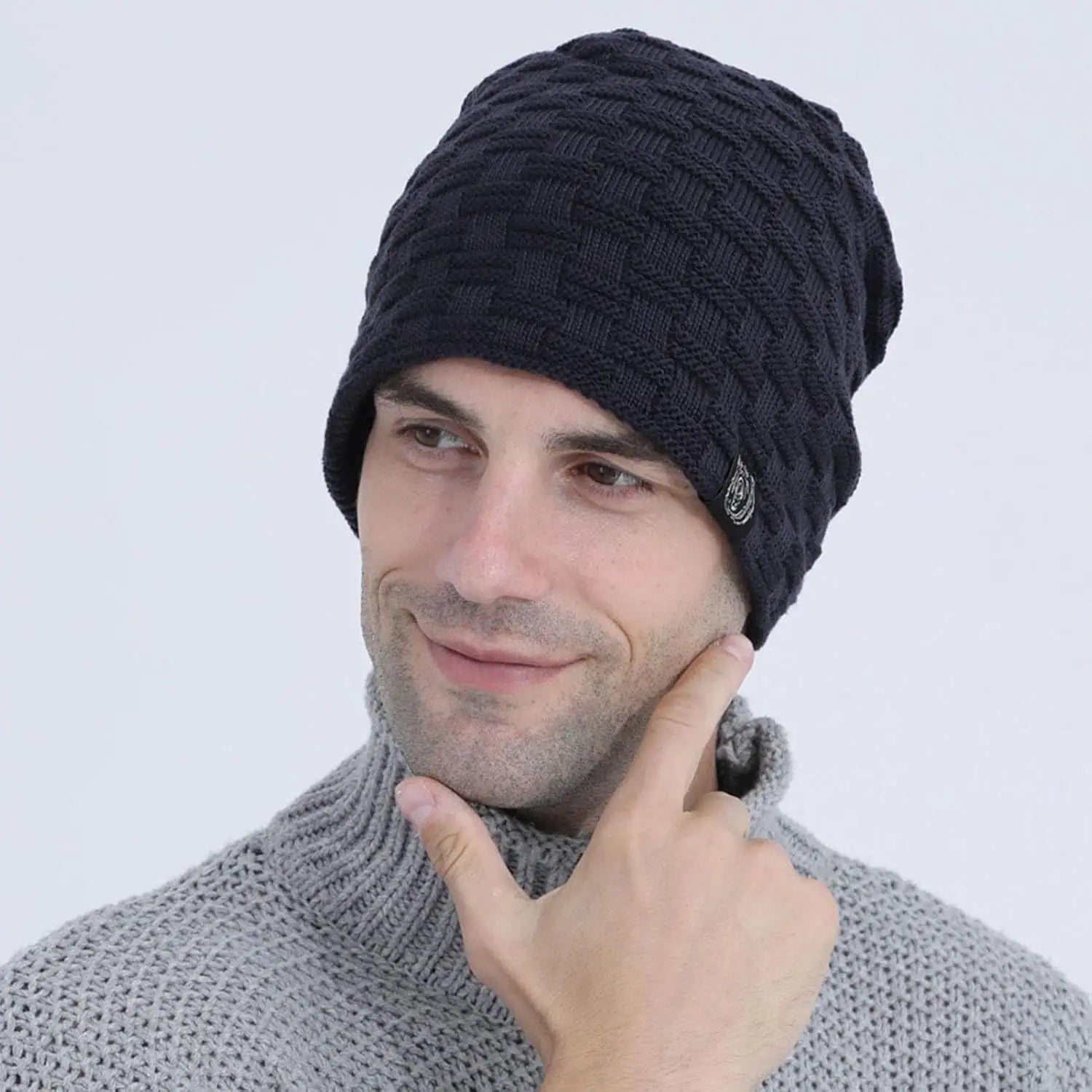 A man wearing a black, plush-lined beanie with a textured, basket-weave knit pattern.