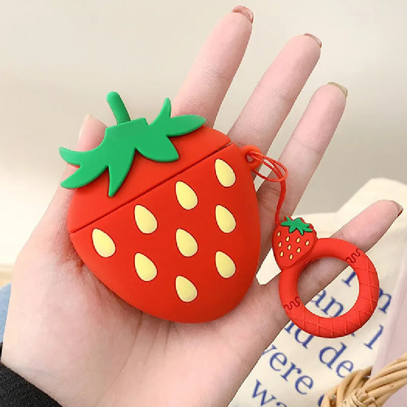 Red silicone strawberry-shaped AirPods case with a matching ring charm, held in a hand.