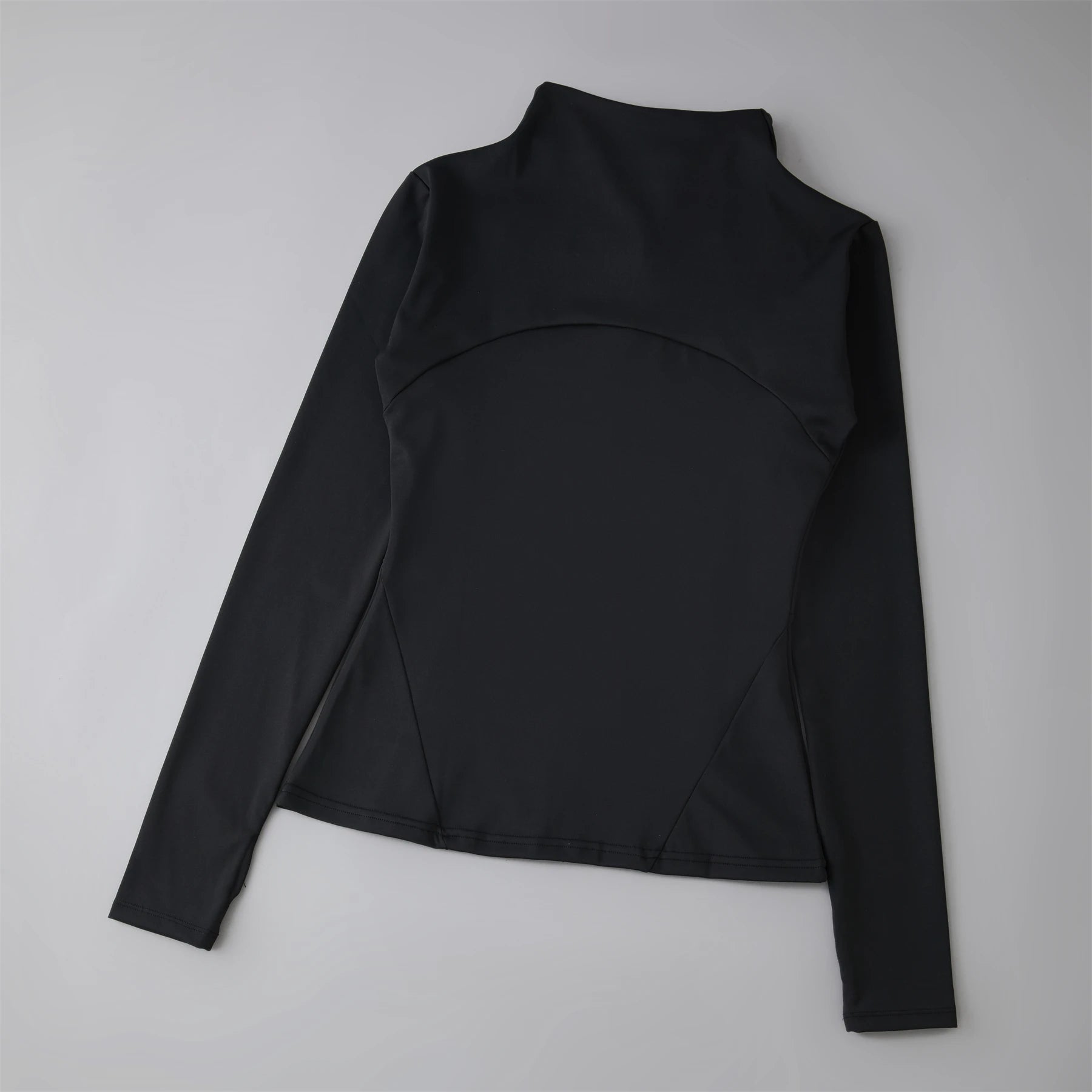 Black long-sleeved athletic top with a mock neck, fitted silhouette, and curved seam detailing on the back.