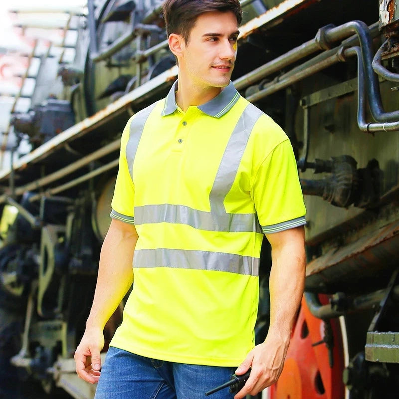 Model wearing a high-visibility yellow polo shirt with grey collar and reflective strips on torso and sleeves.