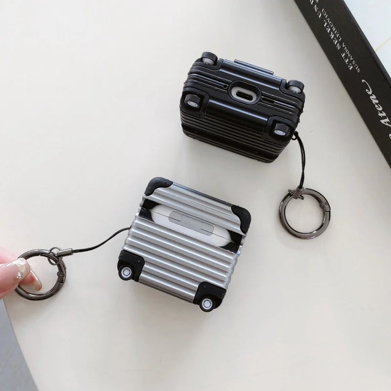 Black and silver hard-shell suitcase-style protective cases for Apple AirPods with metal keyring clips.