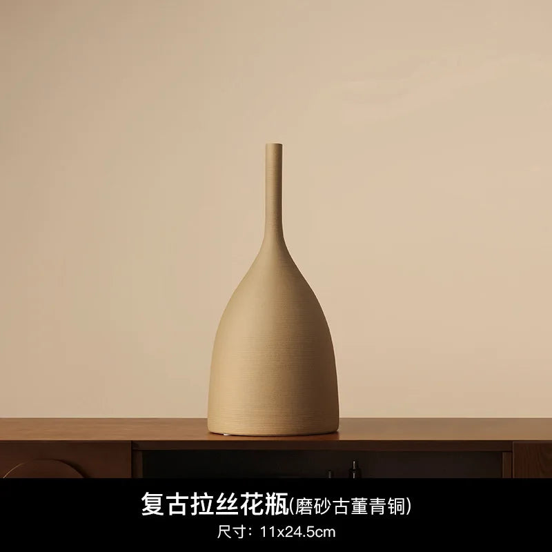 Minimalist, beige handmade ceramic vase with a textured matte finish and a slender, tall neck.