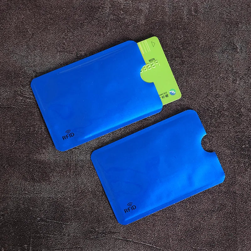 Two blue, thin plastic RFID-blocking sleeves, one holding a green credit card.