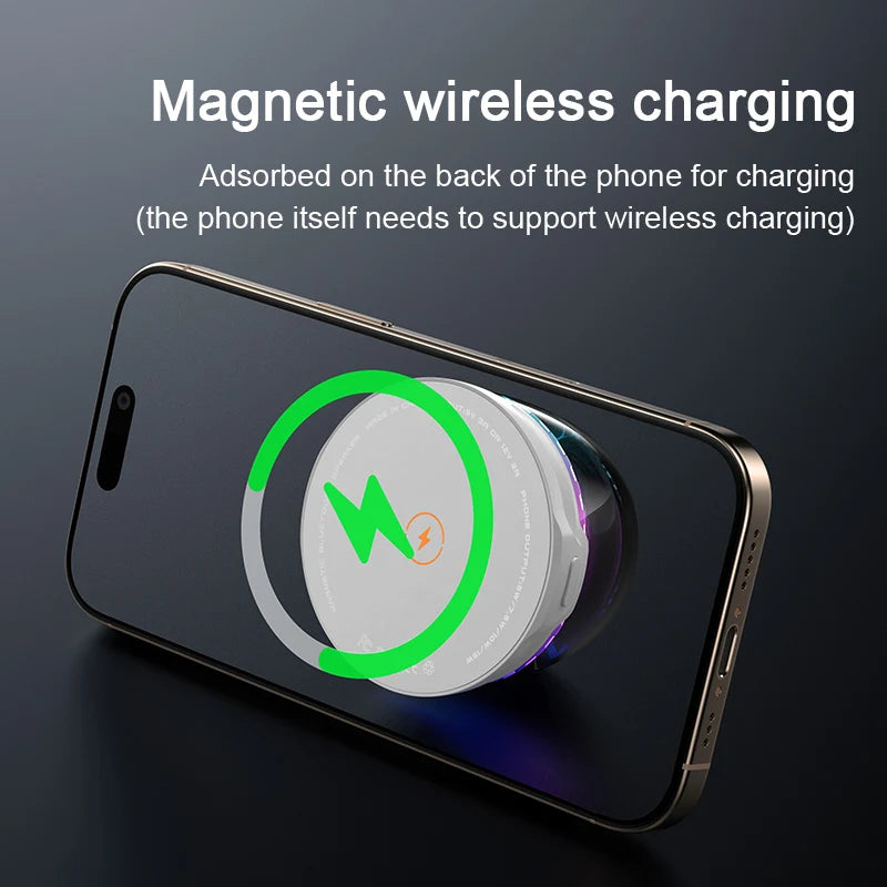 White, round portable magnetic Bluetooth speaker attached to the back of a black smartphone for wireless charging.