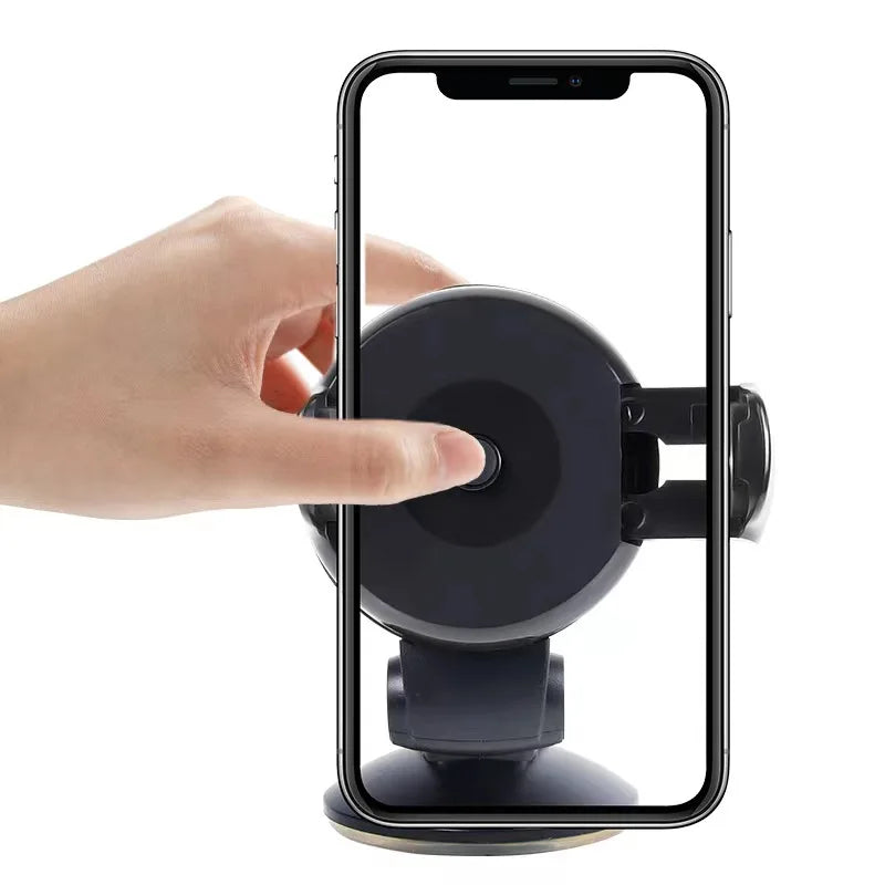 Black car phone mount with adjustable side grips and suction base, shown with a smartphone being held by a hand.