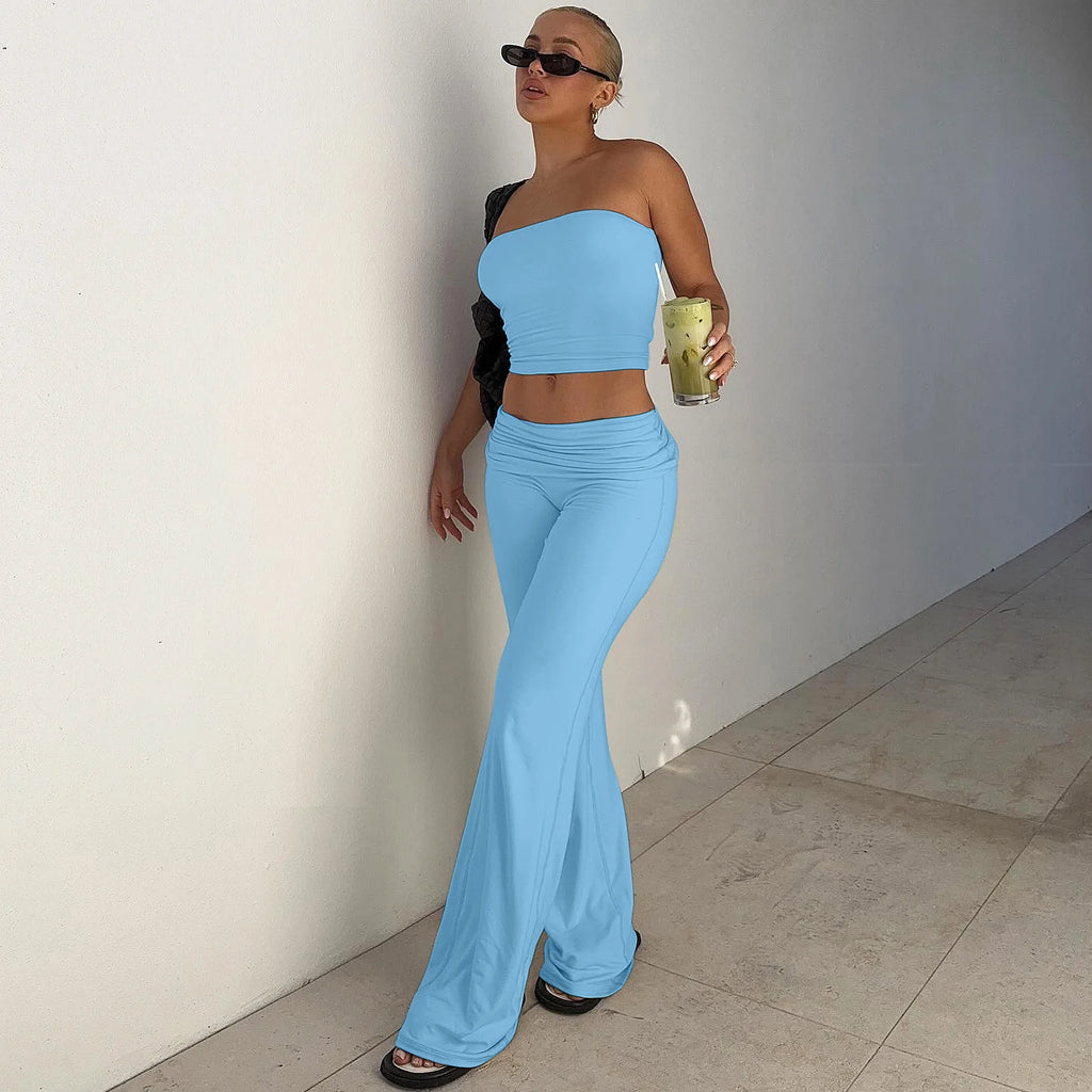 Woman wearing a sky-blue, two-piece set featuring a strapless crop top and matching high-waisted wide-leg trousers.