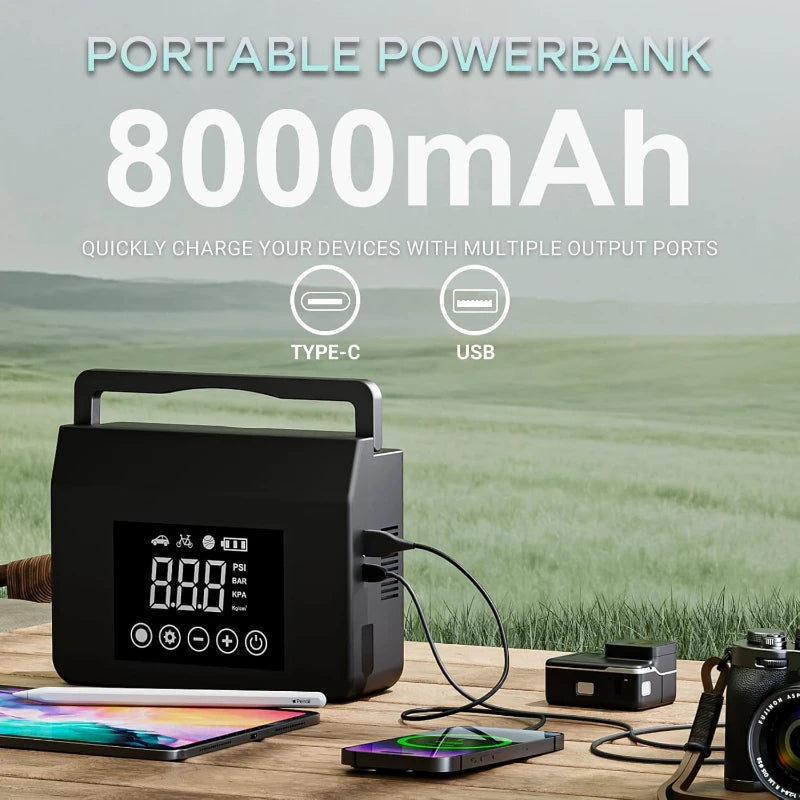 Black rectangular jump starter with top handle, digital display screen, and control buttons on an outdoor table.