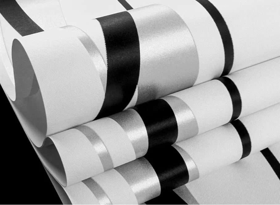 Modern wallpaper featuring a geometric stripe pattern in matte black, metallic silver and white with a textured finish.