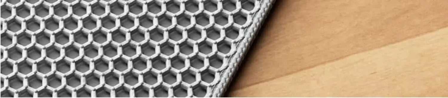 Grey waterproof cat litter mat with a textured honeycomb surface design, resting on a light wood floor.