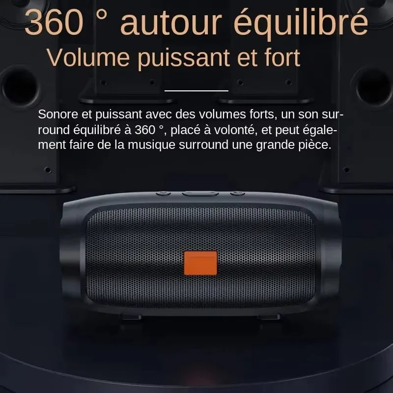 Cylindrical black portable Bluetooth speaker with a central orange accent, designed for 360-degree surround sound.