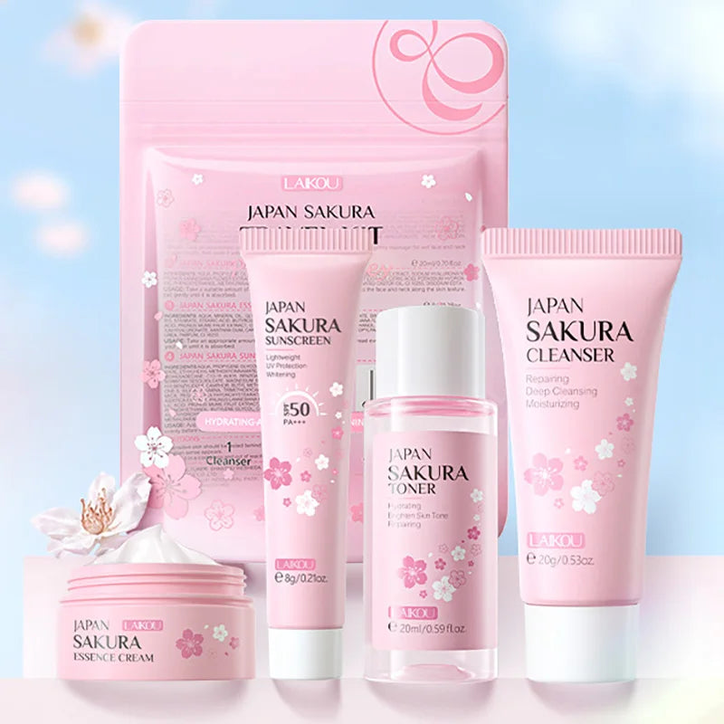 Pink sakura-themed skincare travel kit featuring a cleanser, toner, sunscreen, and cream in a matching pouch.