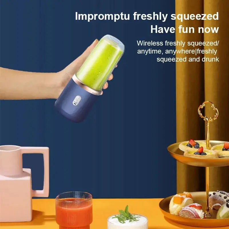 A hand holds a portable, navy blue and rose gold wireless blender filled with a green smoothie against a blue backdrop.