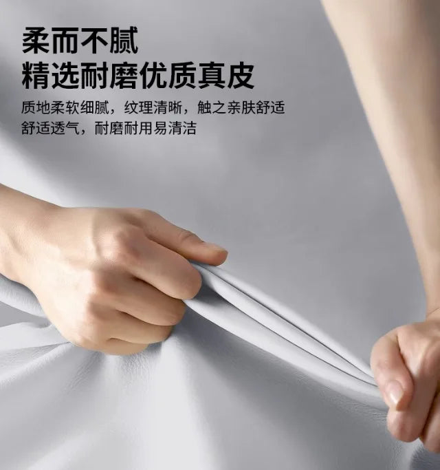 Close-up of hands stretching soft, high-quality grey genuine leather upholstery for a premium bed frame.