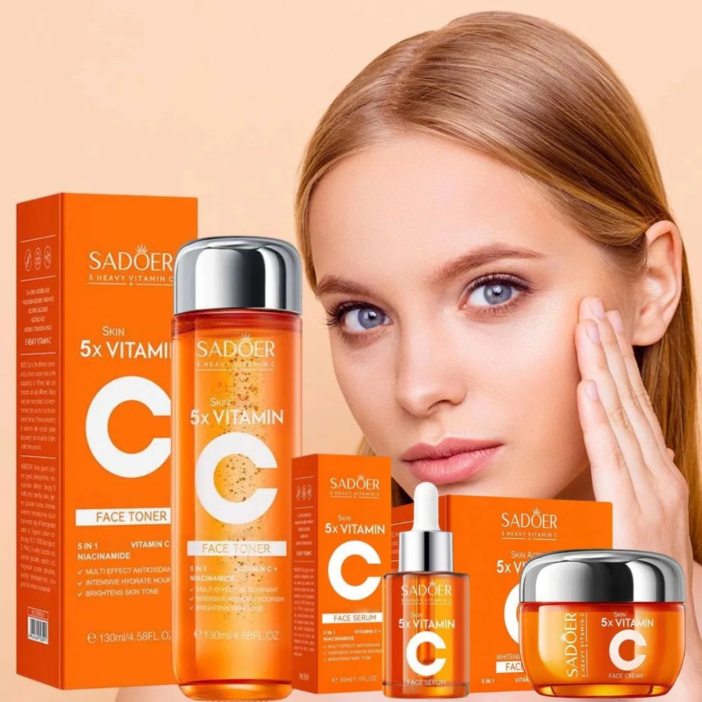 Vitamin C face care set with toner, serum, and cream in bright orange packaging, displayed with a woman touching her face.