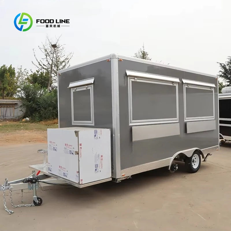 Grey rectangular mobile food trailer with a hitch, service windows, and a wrapped equipment box.