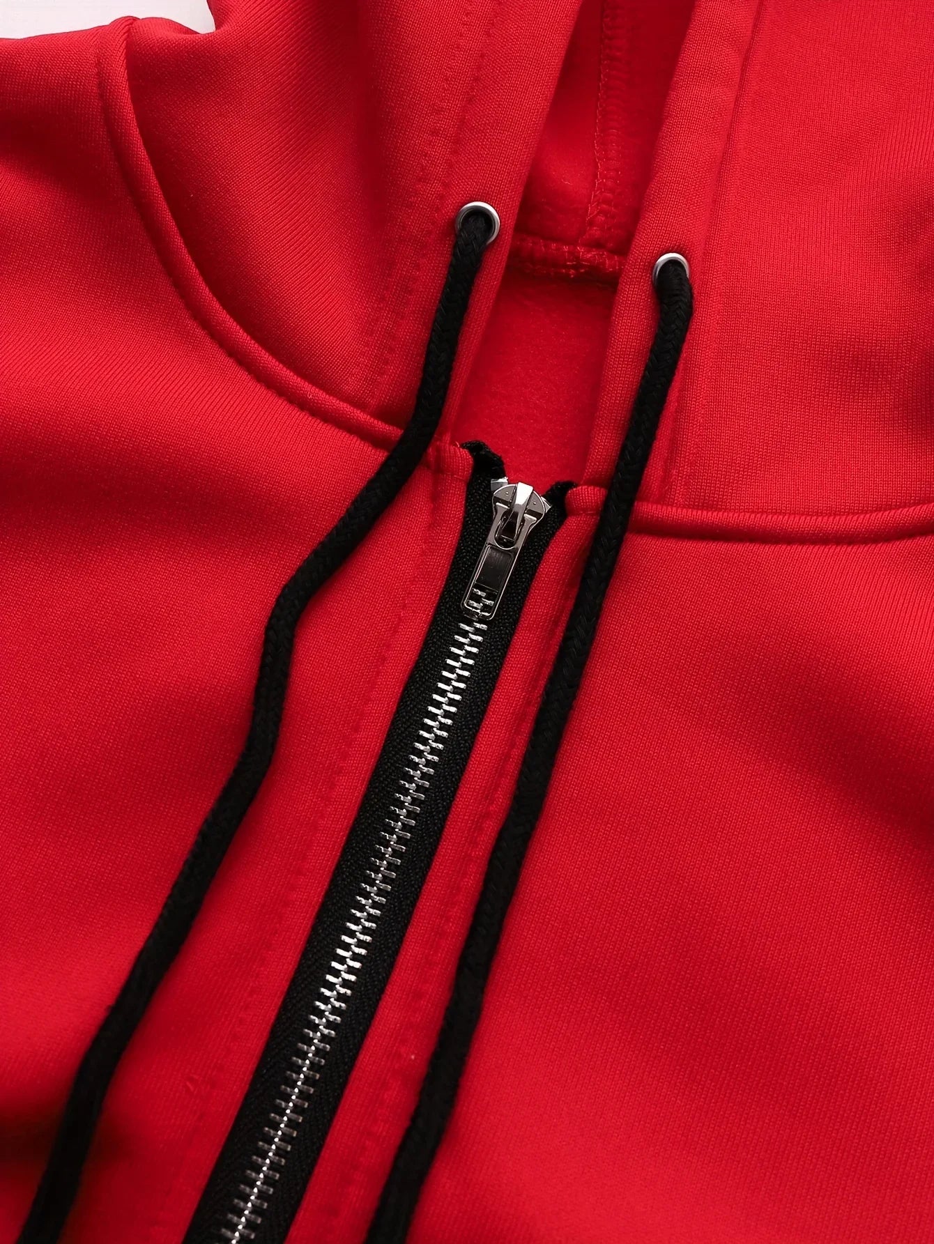 Bright red zip-up hoodie featuring a black-trimmed hood, matching black drawstrings, and a metallic silver zip.