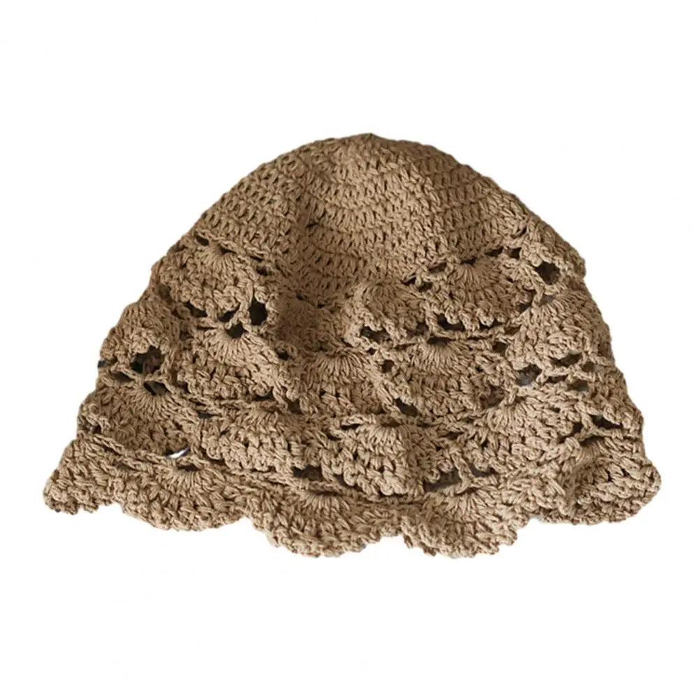 Beige crochet lace bucket hat with an intricate hollow-out floral pattern and scalloped edge.