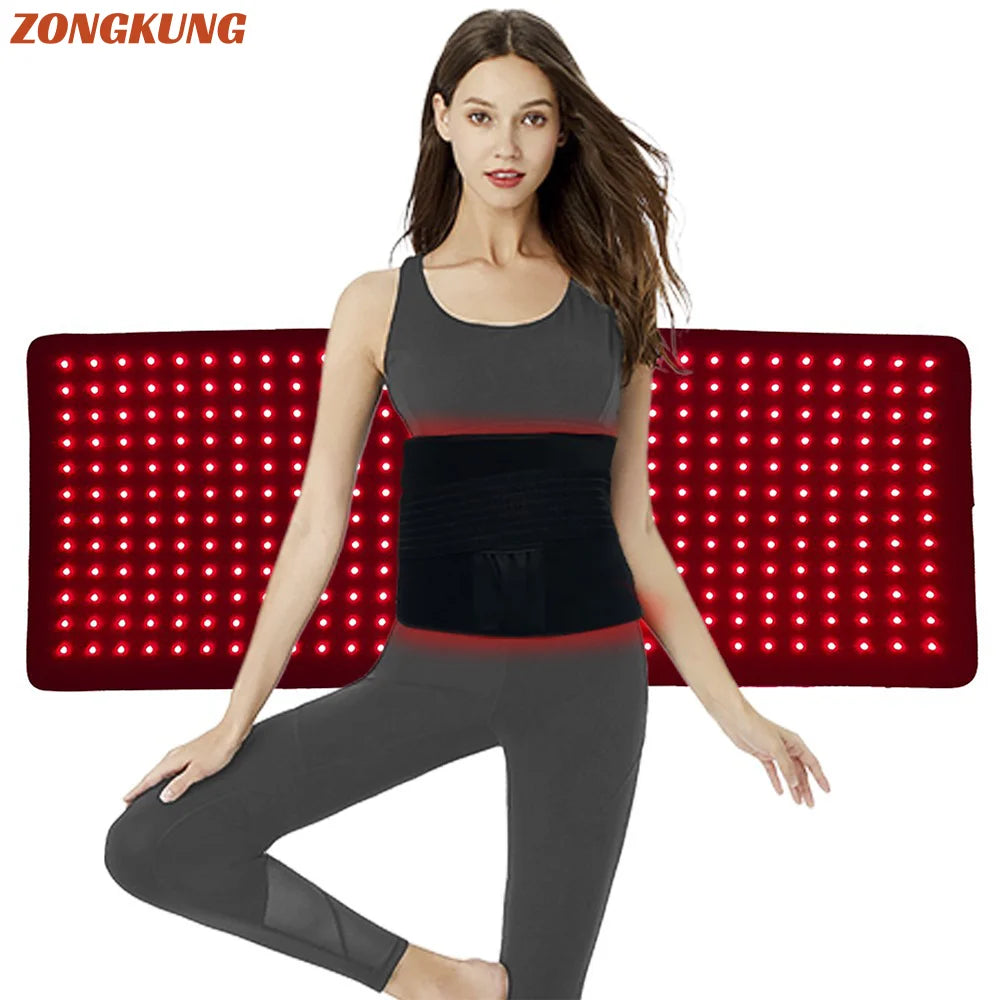 A woman wearing a black waist belt in front of a red light therapy mat.