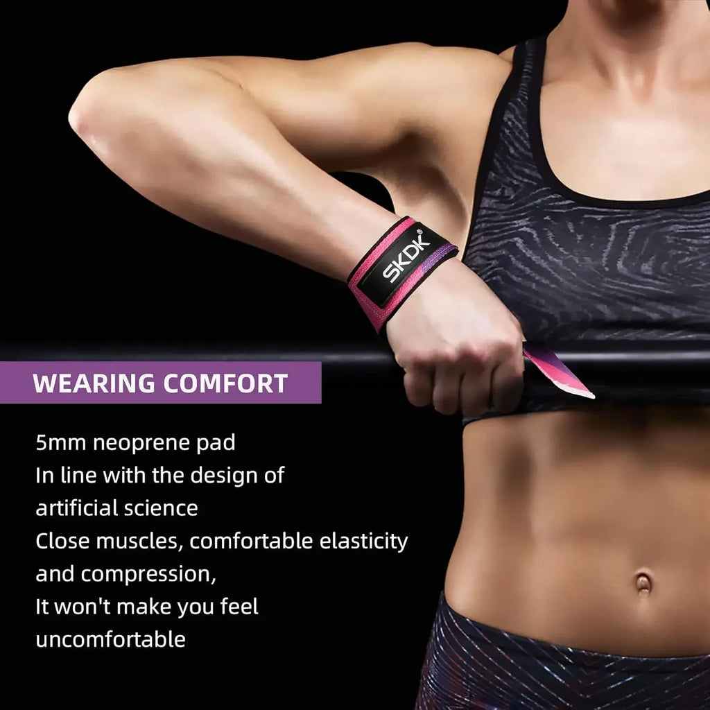 Person wearing a pink and black SKDK weightlifting wrist support strap on their wrist while holding a barbell.