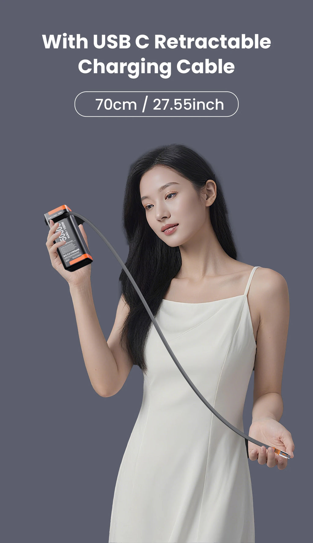 A woman holding a sleek, black and orange 50,000mAh 100W power bank featuring a built-in retractable USB-C cable.
