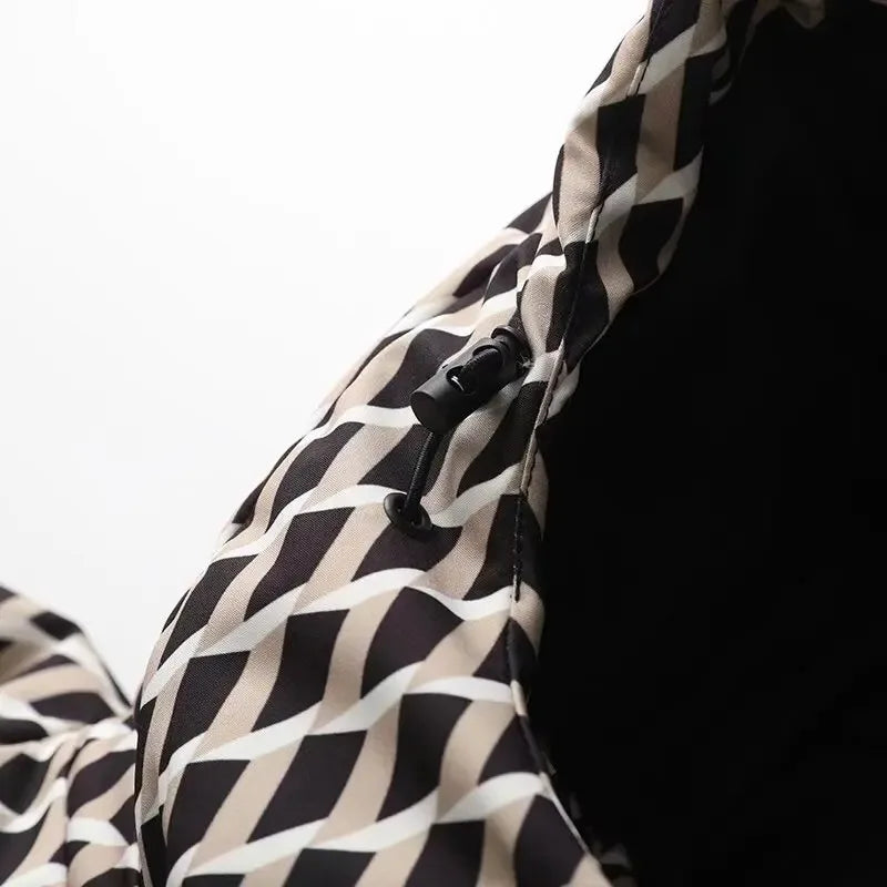 Close-up of a jacket hood with a black, beige, and white geometric diamond pattern and a functional drawstring toggle.