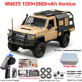 Tan 1/12 scale 4WD RC off-road truck with black accessories, remote control, and spare parts.