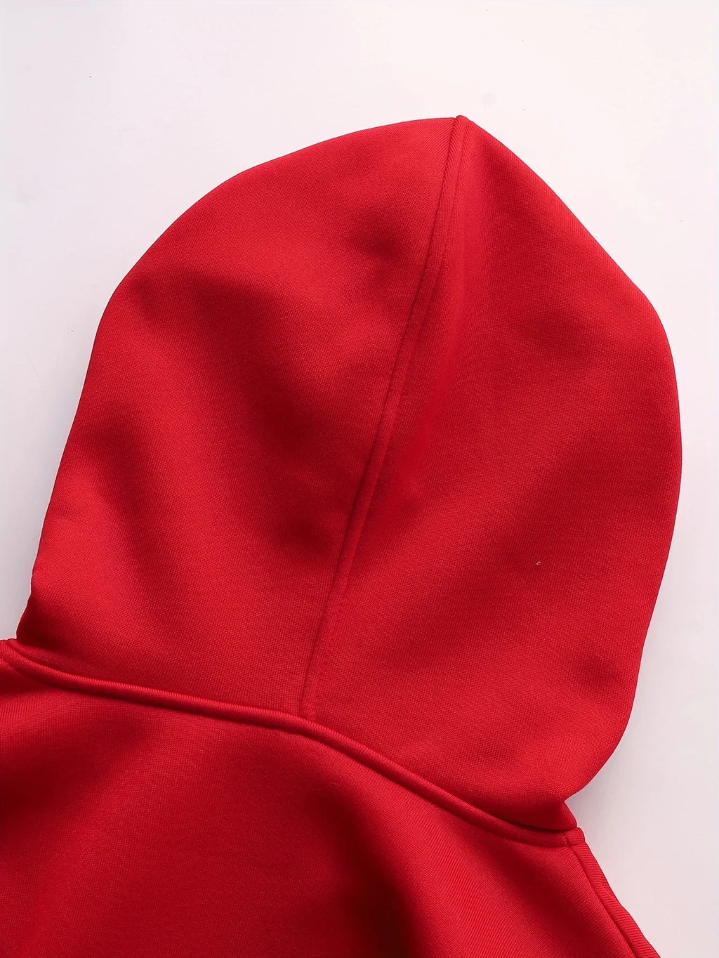 Close-up of a vibrant red hoodie with a smooth, clean design and central seam detail on the hood.