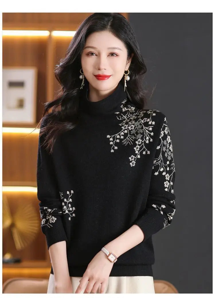 Black turtleneck jumper with white floral embroidery detail on the shoulder and sleeve, featuring a fitted style.