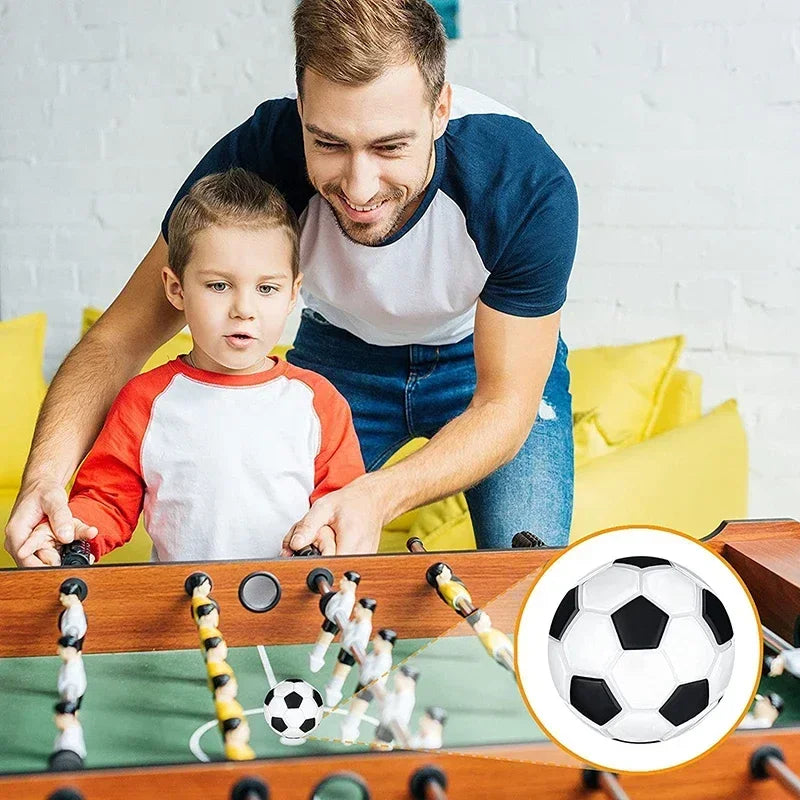 Classic black and white football for table foosball games, shown in play and as a close-up detail.