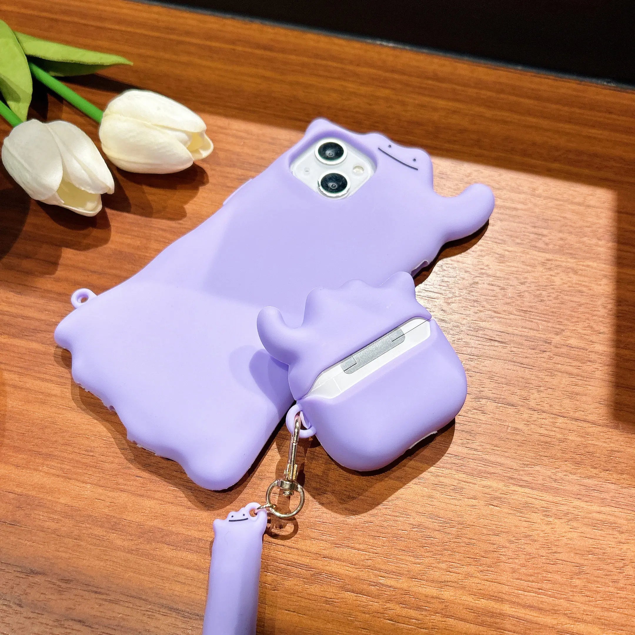 Light purple, soft-touch silicone AirPods case featuring a whimsical character design and matching lanyard.