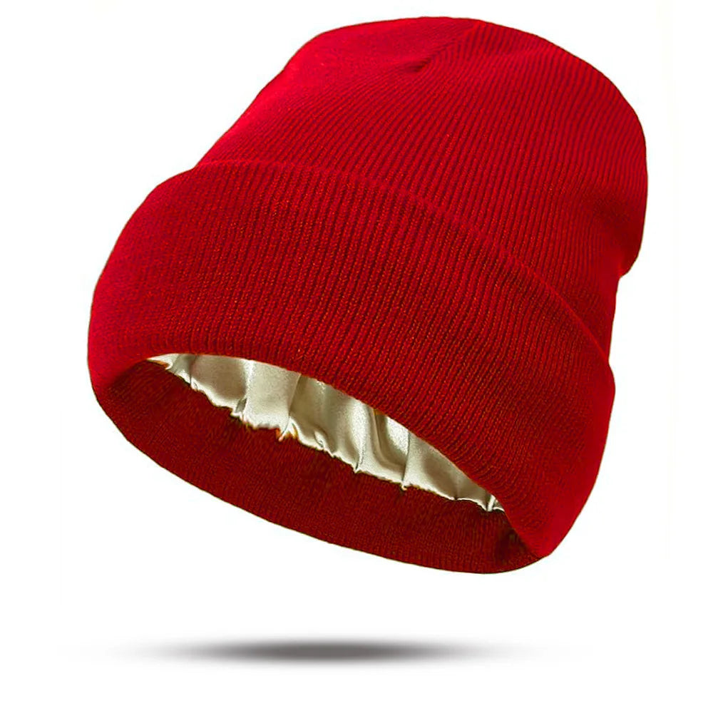 Bright red knitted beanie hat featuring a smooth, cream-coloured satin lining.