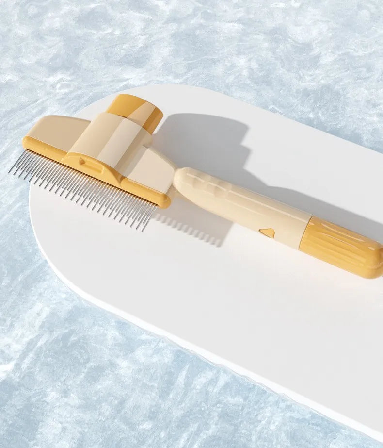 A beige and yellow pet grooming rake with metal teeth, resting on a white surface with a water-ripple background.
