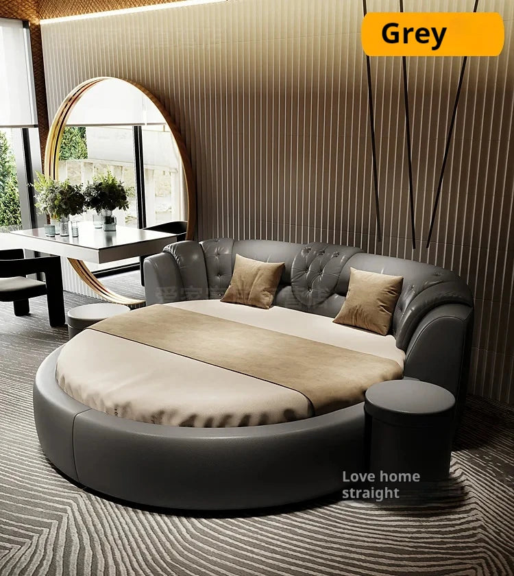 Modern luxury round grey double bed with a button-tufted curved headboard, beige bedding, and a matching side stool.