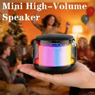 A hand holding a compact, black wireless speaker featuring a colourful, glowing LED light display.