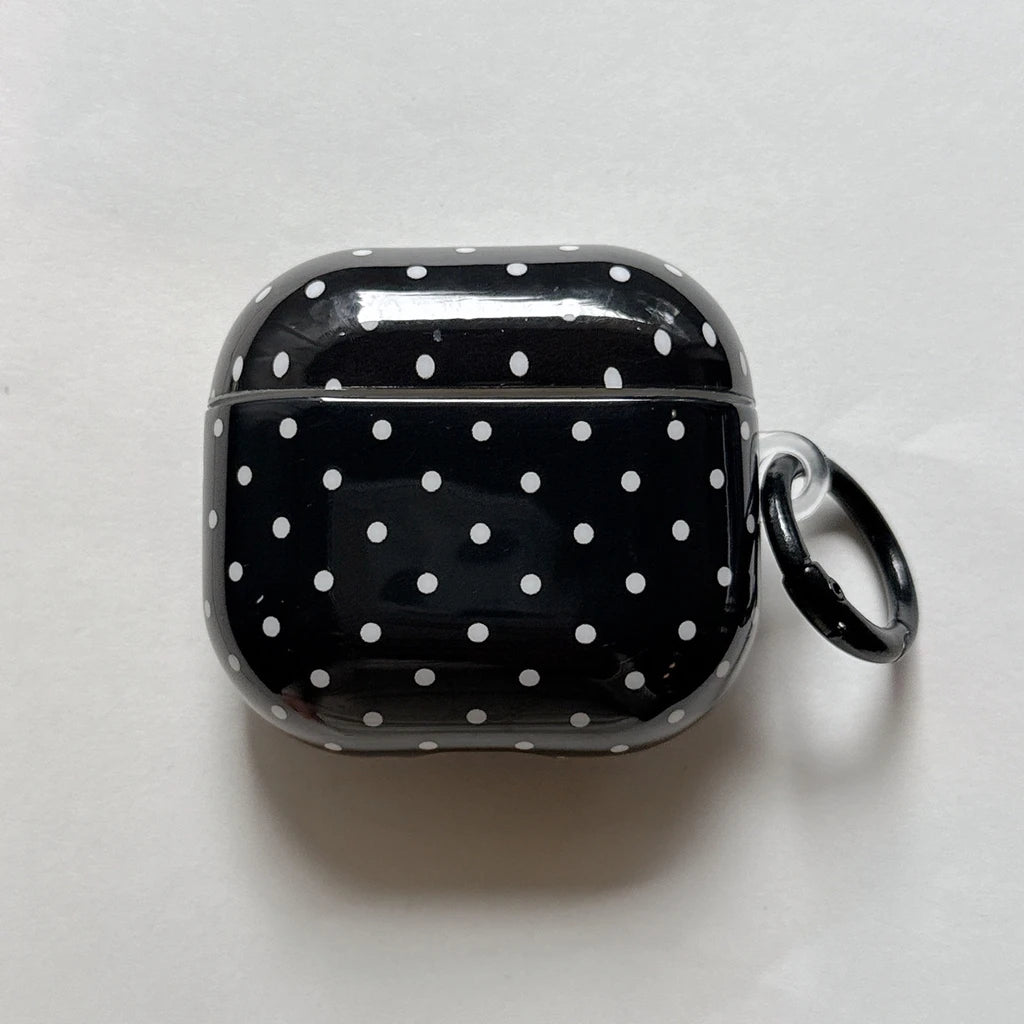 Black glossy AirPods 3 case with white polka dots, featuring a matching black carabiner clip.
