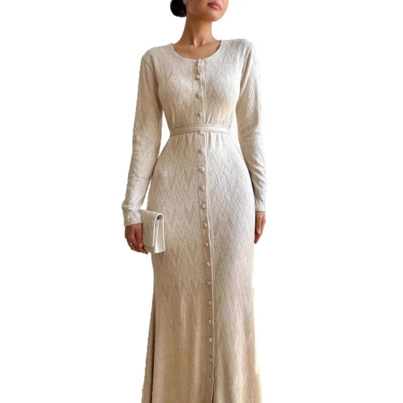 Cream-coloured maxi dress with long sleeves, button-front, textured chevron pattern, and a waist-defining belt.