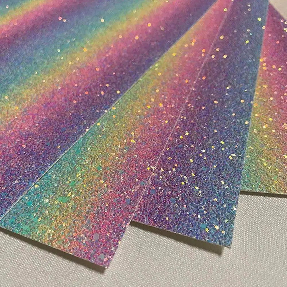 Sheets of iridescent rainbow glitter craft paper with a textured, shimmering finish.