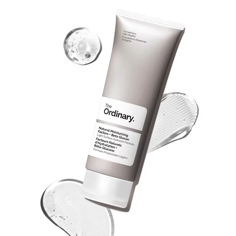 Grey tube of light hydrating face moisturiser with beta glucan, surrounded by clear gel droplets on a white background.