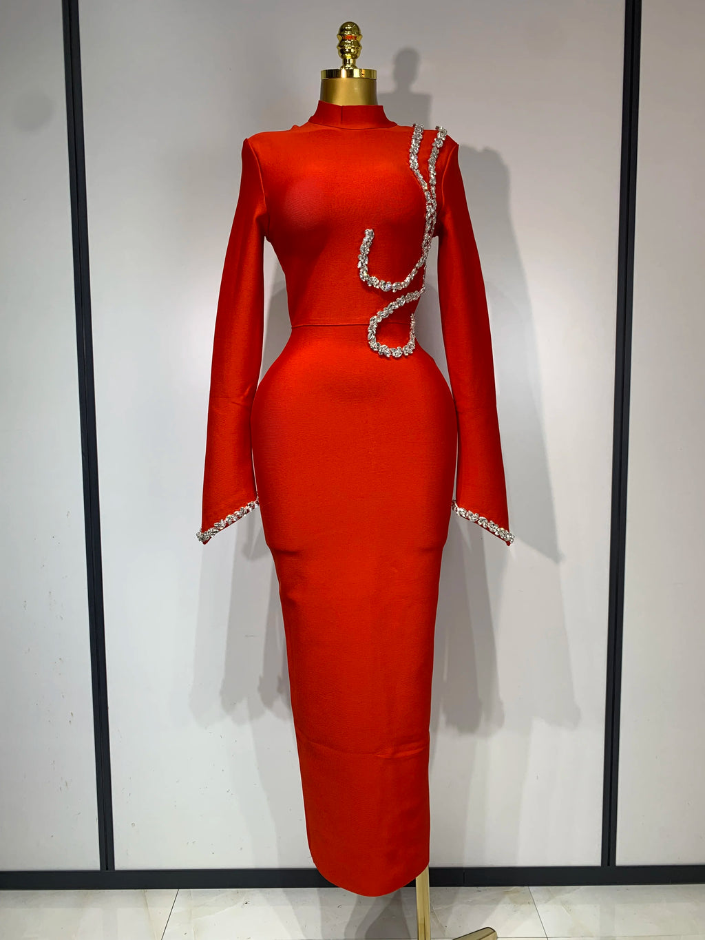 Red long-sleeve bodycon maxi bandage dress featuring sparkling crystal trim on the bodice and cuffs.
