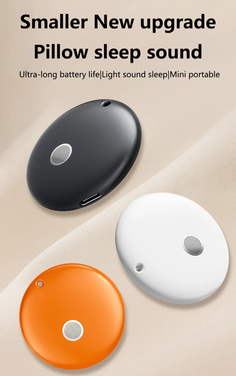 Three small, portable, disc-shaped Bluetooth speakers in black, white, and orange, each with a central speaker mesh.