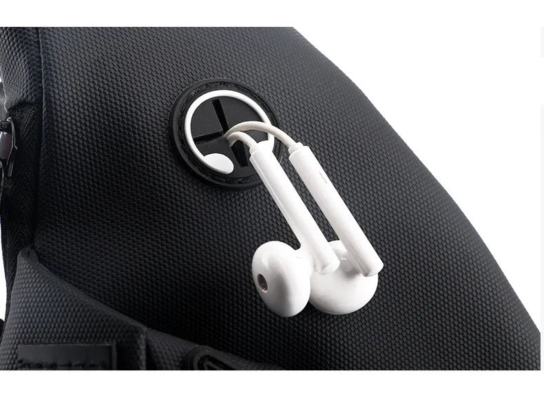 Close-up of a black textured crossbody bag featuring a convenient integrated headphone cable port.