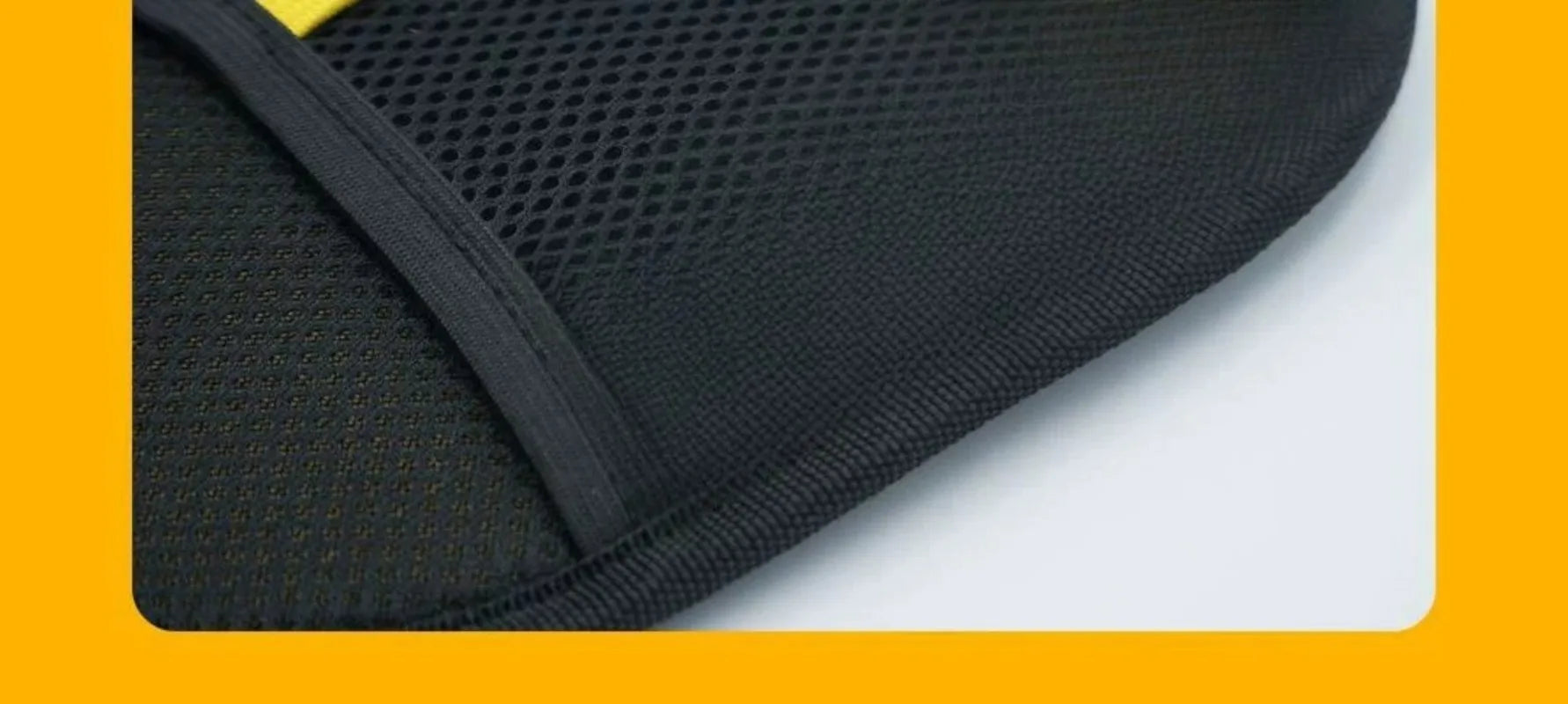 Close-up of a black mesh fabric panel with a structured piped edge and a hint of yellow trim.