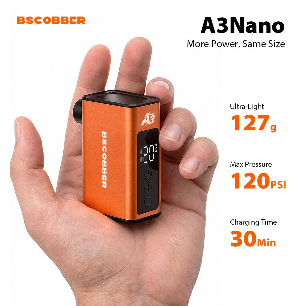 Compact orange BSCOBBER A3Nano mini electric bike air pump held in an open hand, showing its digital display.