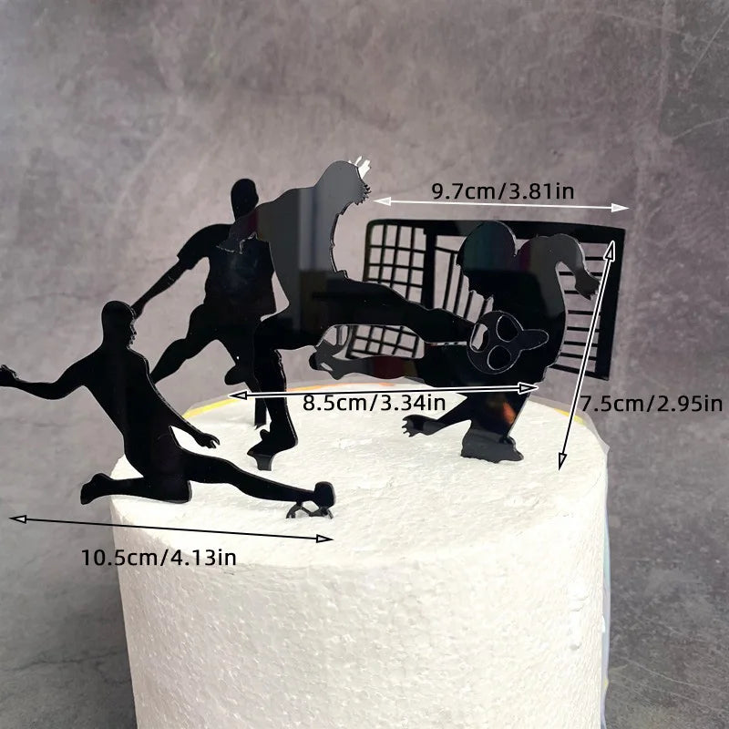 Black acrylic football-themed cake topper showing players in action and a goal net, displayed on a white cake.