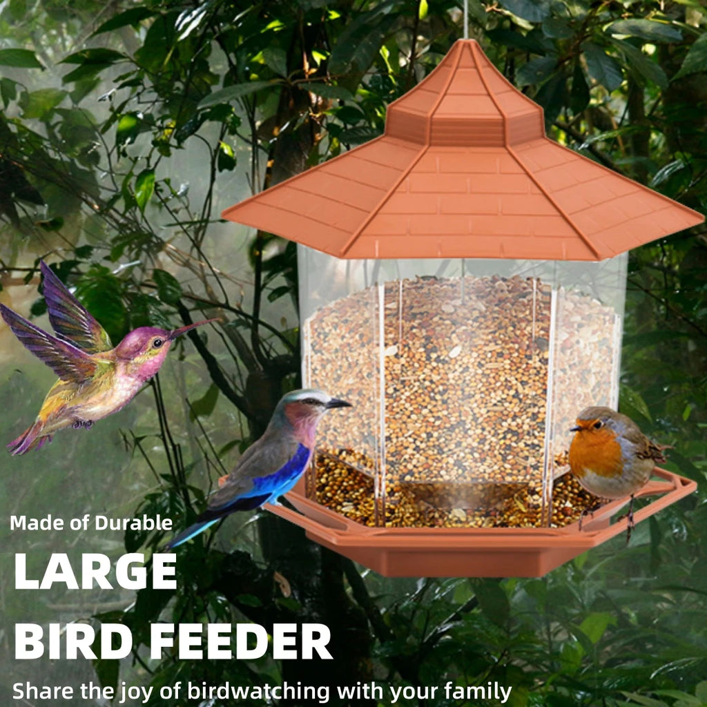 Hexagonal plastic bird feeder with a terracotta roof, transparent seed reservoir, and birds in a garden setting.